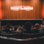 Yleisöä elokuvasalissa, valkokankaalla Rakkautta & Anarkiaa 2023 -logo